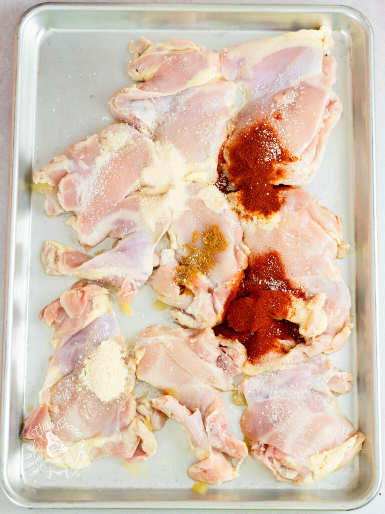 Raw chicken with smoked paprika, cayenne pepper, cumin, onion powder, garlic powder, and salt.